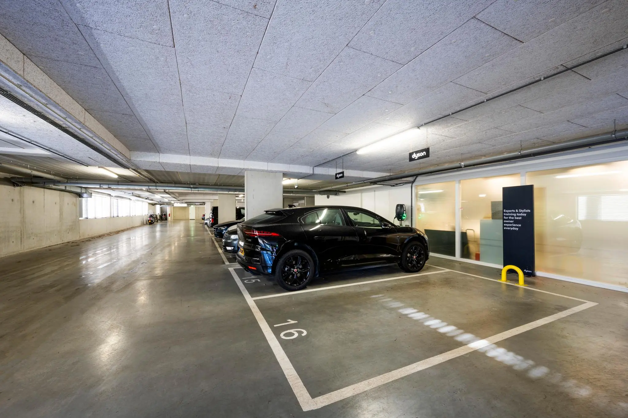 Ondergrondse parkeergarage aan de Fred. Roeskestraat met geparkeerde auto's en oplaadpunt voor elektrische voertuigen.